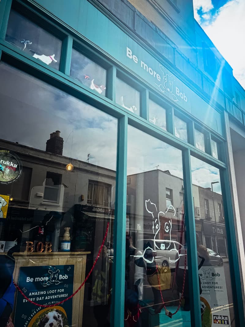 The teal-framed shopfront on Winchcombe Street with dog decals across the glass